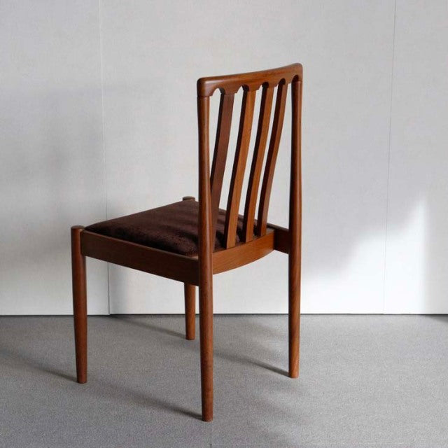 Vintage mid-century teak dining chair by Meredew with slender vertical slats, tapered legs, and brown upholstered seat,.