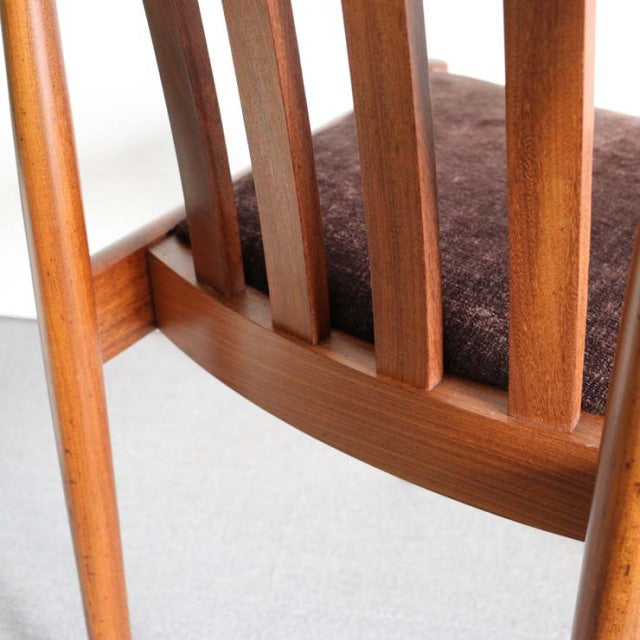Mid-century British Meredew teak dining chair back with warm wood grain and brown upholstered seat.