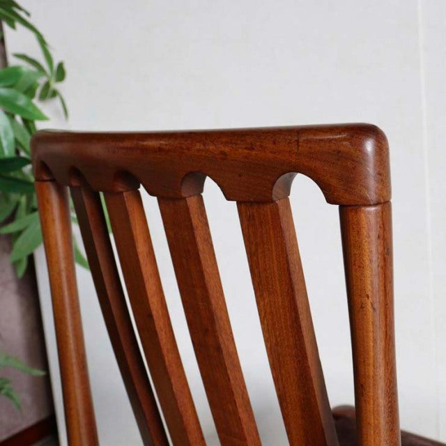 Vintage Meredew teak dining chair backrest with vertical slats, British mid-century design, smooth wood grain and curved top .