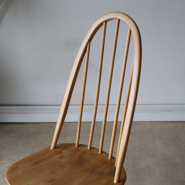 Vintage British Ercol Quaker chair in natural teak with tall curved spindle back and smooth contoured seat, mid-century.