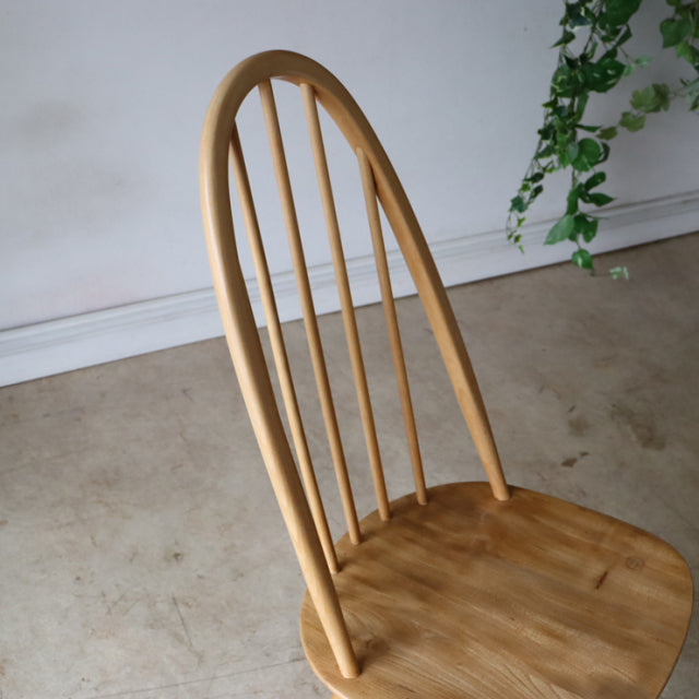Vintage British mid-century Ercol Quaker dining chair in natural teak with curved backrest and slender spindle legs.