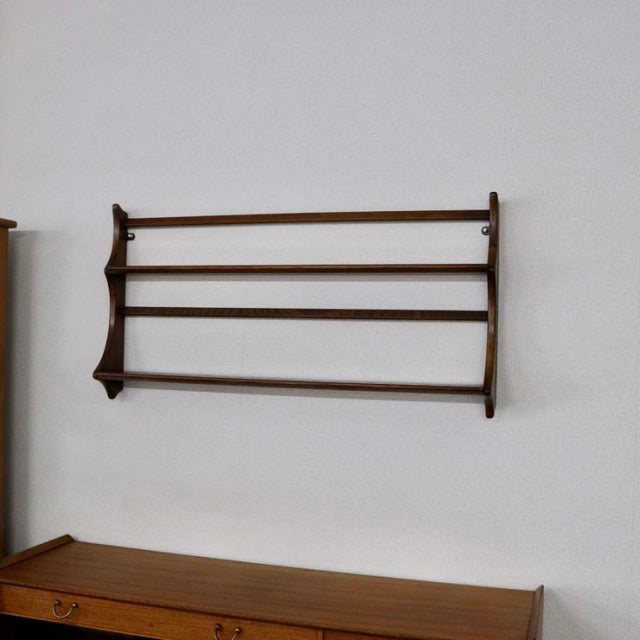 Vintage teak Ercol wall-mounted plate rack with sleek mid-century British design and visible wood grain.