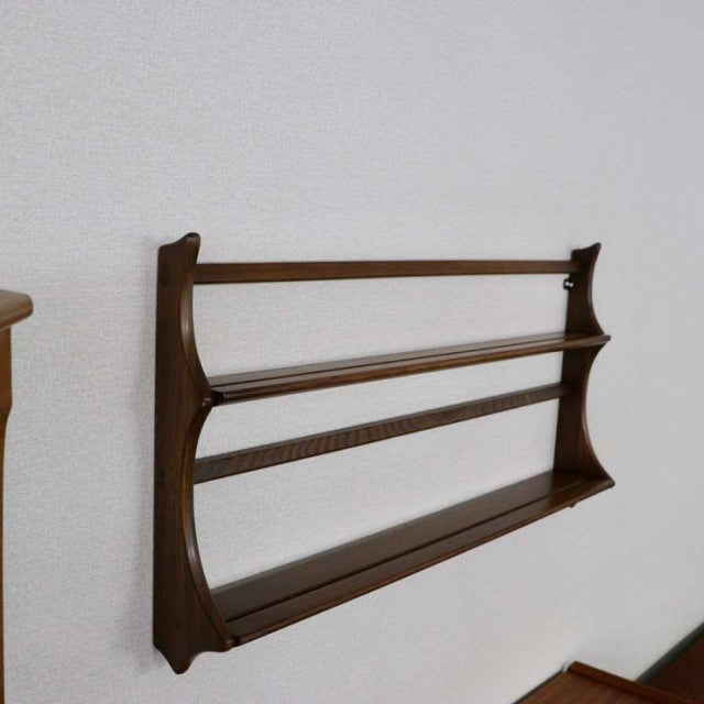 Vintage mid-century British teak Arcoel plate rack with clean lines and visible wood grain mounted on a white wall.