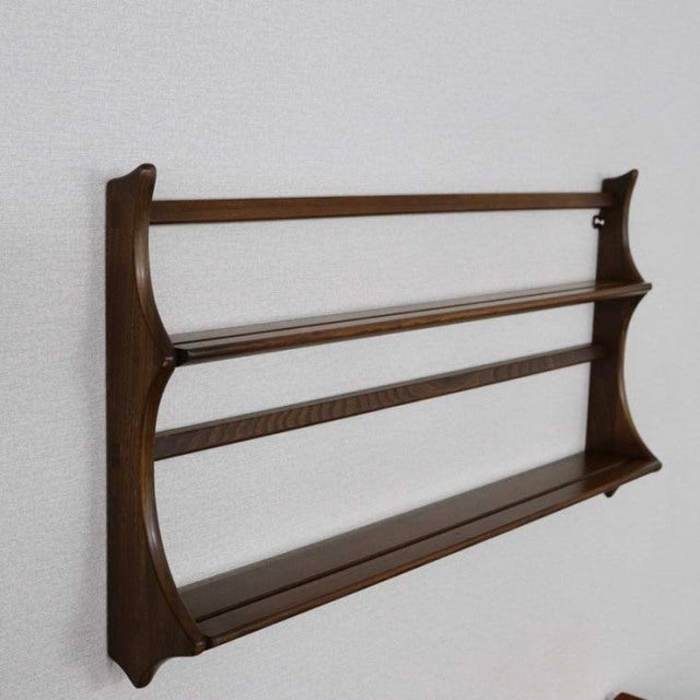 Vintage British mid-century teak Arcol plate rack with smooth wood grain, gently curved sides, and two horizontal rails.