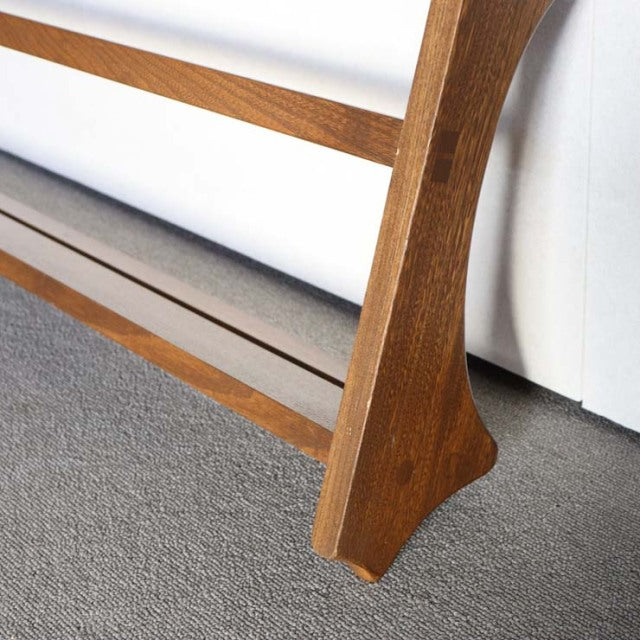 Close-up of vintage teak Arcol plate rack leg with visible wood grain and mid-century British design details against neutral .