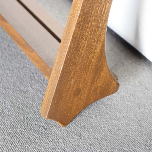 Vintage British mid-century Ercol teak plate rack leg with smooth grain and tapered design on gray carpet.