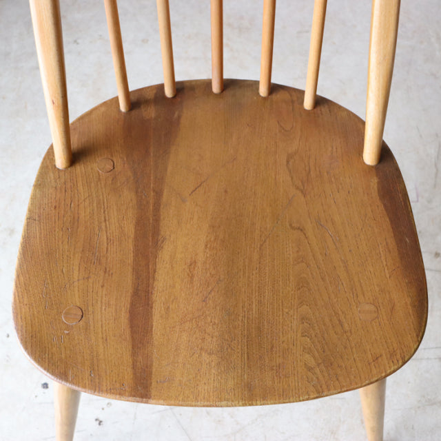 Vintage British Ercol Quaker chair seat in warm teak with smooth wood grain and slender spindled backrest legs.