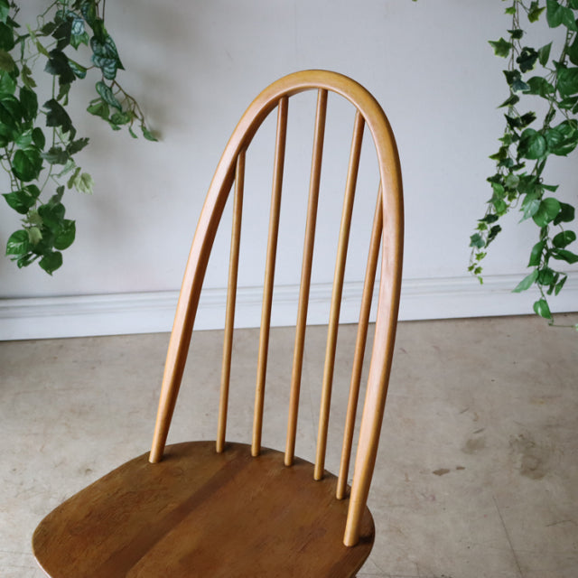 Natural teak vintage Ercol Quaker dining chair with slender spindle back and smooth curved top, British mid-century design.