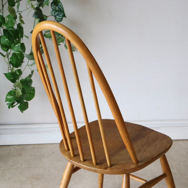 British mid-century vintage Ercol Quaker chair in natural teak with spindle back and gently curved legs.