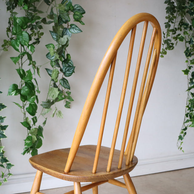 Vintage ERCOL Quaker chair in natural teak with slender rounded spindle back and smooth curved legs, British mid-century.