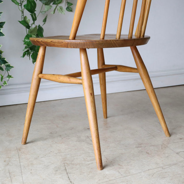 Vintage ERCOL Quaker chair in natural teak with smooth wood grain, slender tapered legs, and mid-century British design.