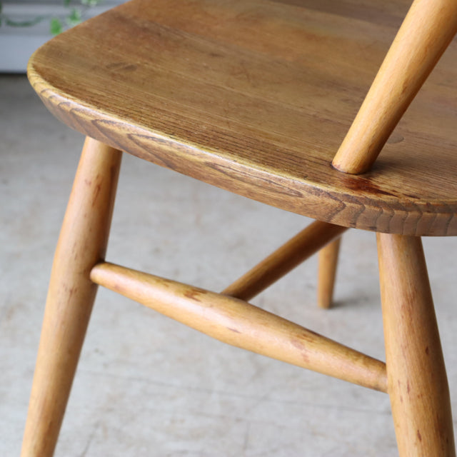 Close-up of vintage British Ercol Quaker chair seat and legs in natural teak with visible wood grain and mid-century Denmark .