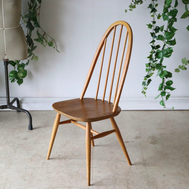 Vintage British mid-century Ercol Quaker chair in natural teak with slender spindled backrest and tapered legs.