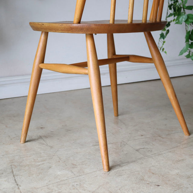 Vintage British mid-century ERCOL Quaker chair in natural teak with tapered legs and visible wood grain.