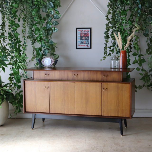 Vintage G-Plan teak sideboard with sleek mid-century British design, tapered black legs, and warm wood grain finish.