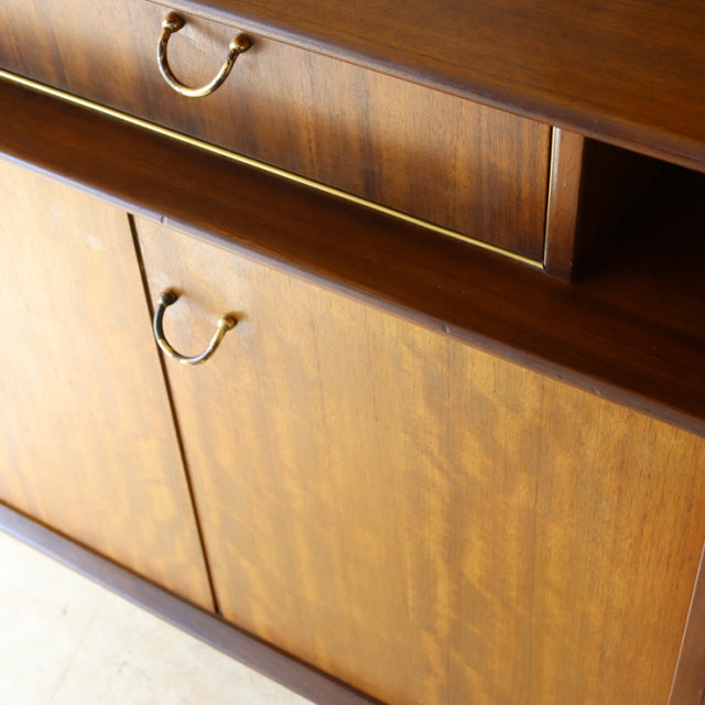 Vintage British mid-century G-Plan teak sideboard with rich wood grain, rounded brass handles, and elegant tapered legs from .