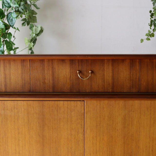 Vintage British mid-century G-Plan teak sideboard with rich wood grain, brass handle, and clean lines.