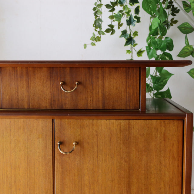 Vintage teak G-Plan sideboard with smooth wood grain, brass handles, and clean mid-century British design lines.