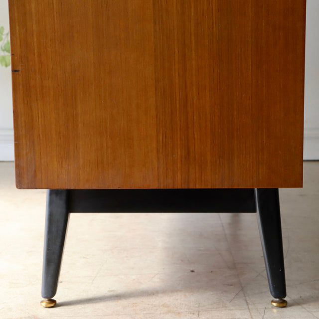 Vintage G-Plan teak sideboard leg with tapered black wooden design and brass-capped feet, mid-century British style.