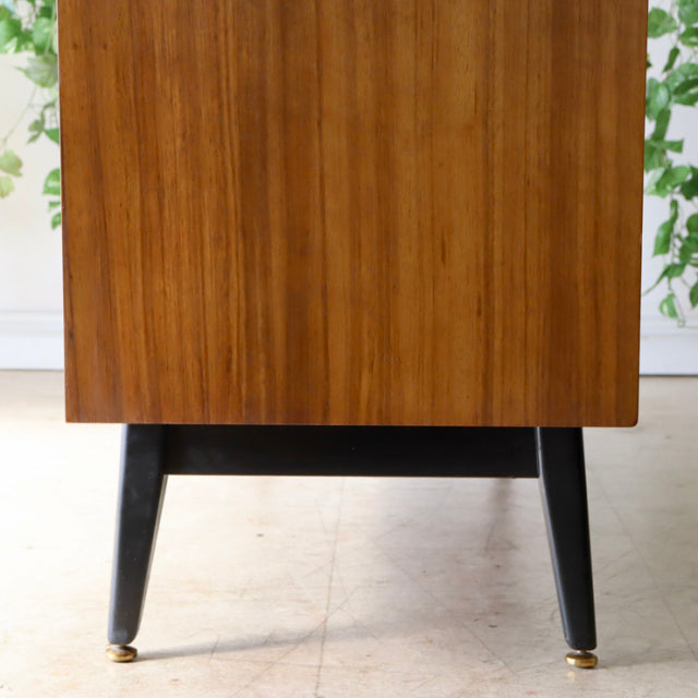 Vintage teak G-Plan sideboard showcasing rich wood grain and sleek mid-century British design with tapered black legs.