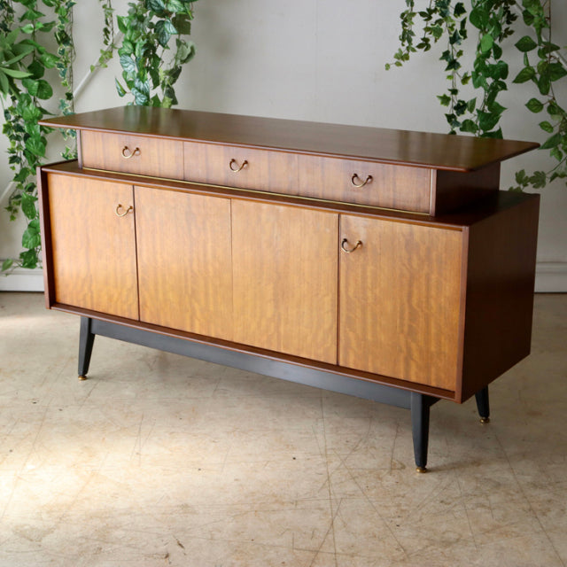 Vintage teak G-Plan sideboard with British mid-century design, rich wood grain, tapered legs, and rounded drawer pulls.