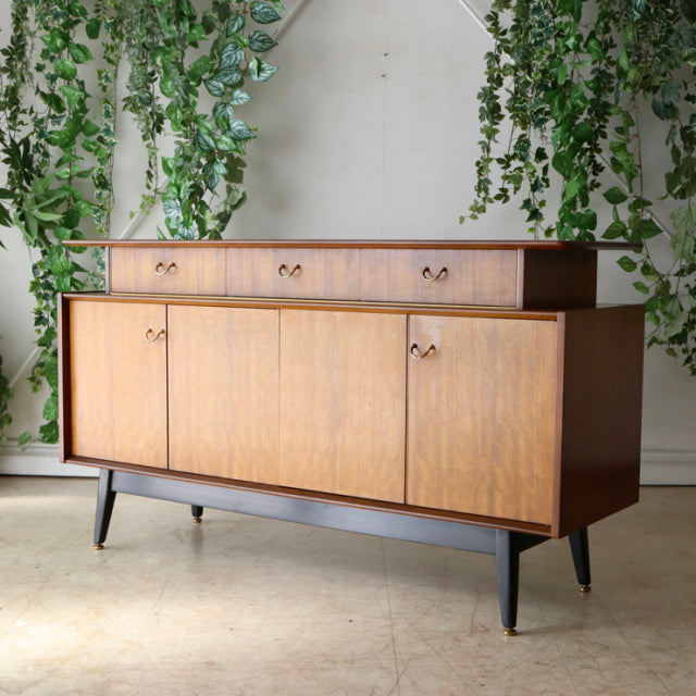 Vintage G-Plan teak sideboard with British mid-century design, showcasing rich wood grain, sleek tapered legs, and.