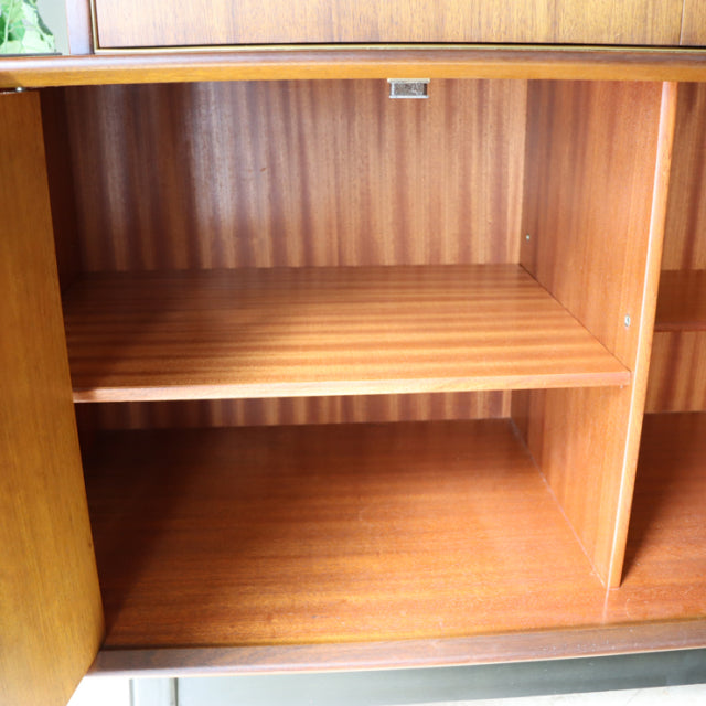 Open teak cabinet interior showing rich wood grain and adjustable shelf in British mid-century G-Plan sideboard.