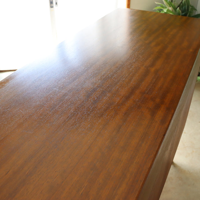 Vintage British mid-century teak G-Plan sideboard top showcasing smooth wood grain and warm brown finish.