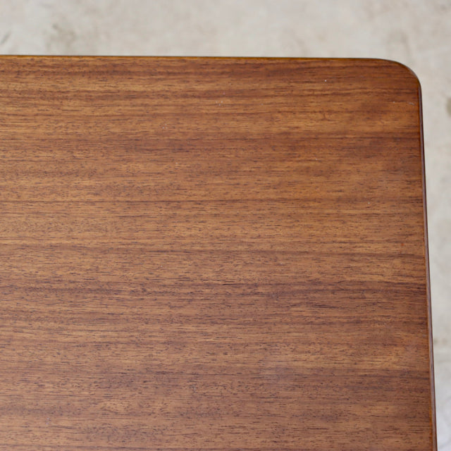 Close-up of vintage British G-Plan teak sideboard top showcasing smooth wood grain and rounded corner detail.