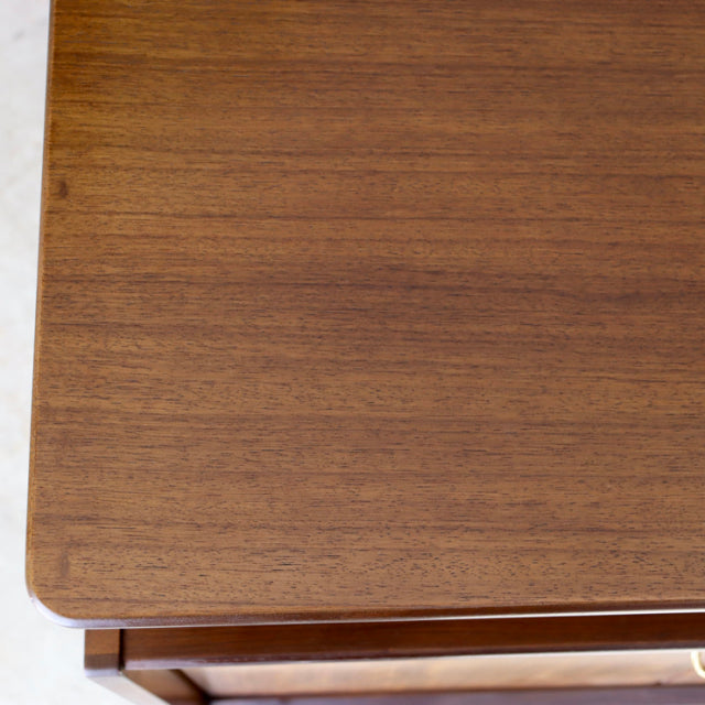 Close-up of vintage British G-Plan teak sideboard top showcasing smooth wood grain and mid-century craftsmanship.
