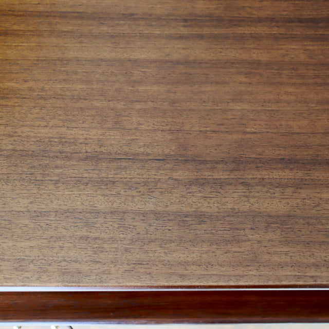 Close-up of vintage teak wood grain on mid-century British G-Plan sideboard surface with smooth finish.