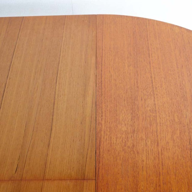 Close-up of vintage British mid-century teak dining table top with smooth grain and rounded edges from Denmark.