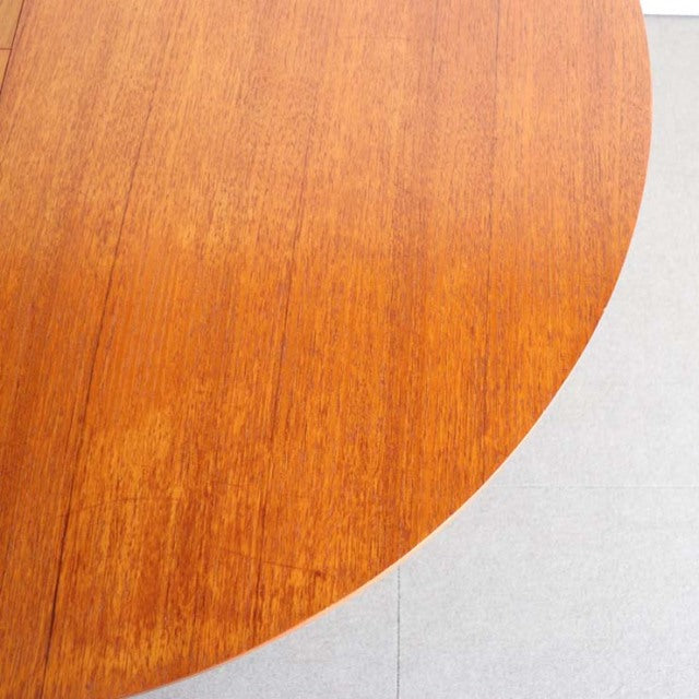 Round vintage mid-century teak dining table top showcasing rich wood grain and warm British-Danish craftsmanship.