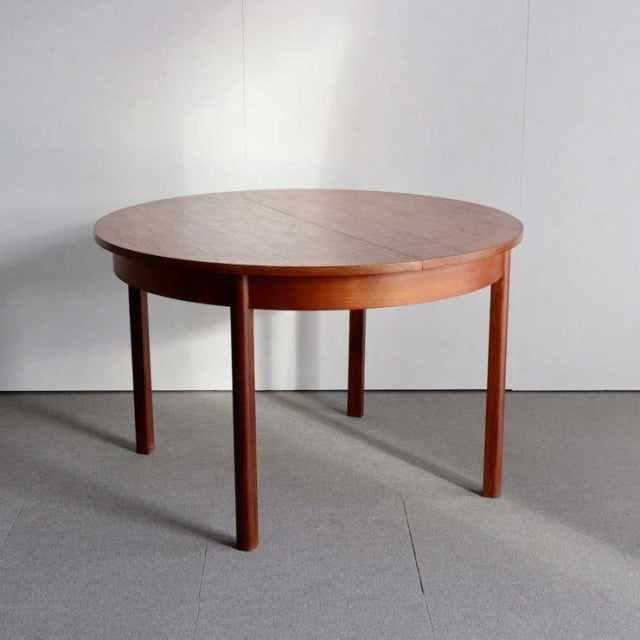 Vintage mid-century British teak dining table with rounded top and tapered legs, Denmark design influence.