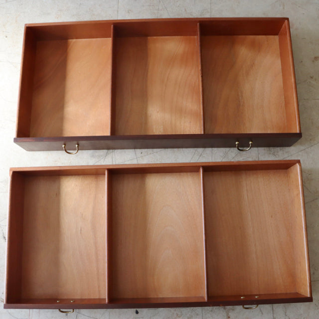 Two open teak drawers with visible wood grain and brass ring handles from British mid-century G-Plan vintage sideboard.