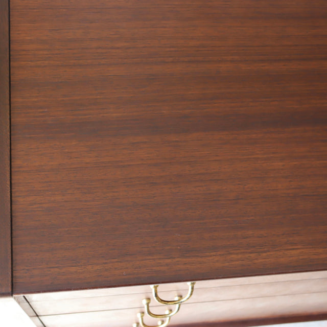 Close-up of vintage British G-Plan teak sideboard showing rich wood grain and brass handle detail from mid-century Denmark.