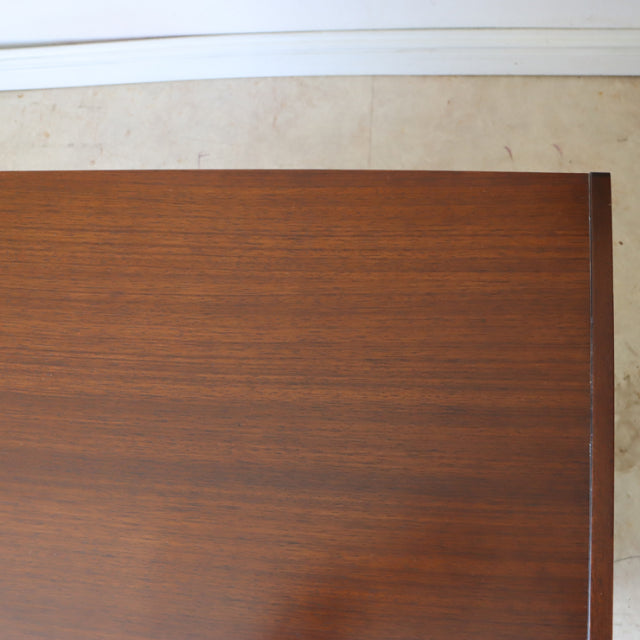 Vintage British G-Plan mid-century teak chest with rich wood grain and sleek black accents, rectangular top.