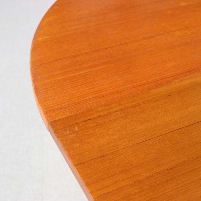 Round mid-century British vintage teak dining table with rich wood grain and smooth edges.