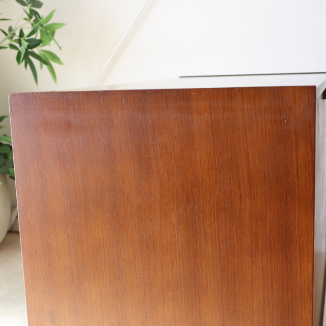 Vintage British mid-century G-plan teak four-drawer chest with smooth wood grain and tapered legs.