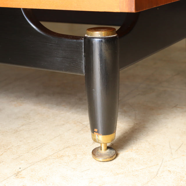 Black tapered wooden leg with brass cap and adjustable foot, vintage mid-century British G-Plan teak sideboard detail.