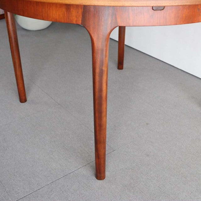 Mid-century British vintage teak round dining table leg with smooth wood grain and tapered design from McIntosh.
