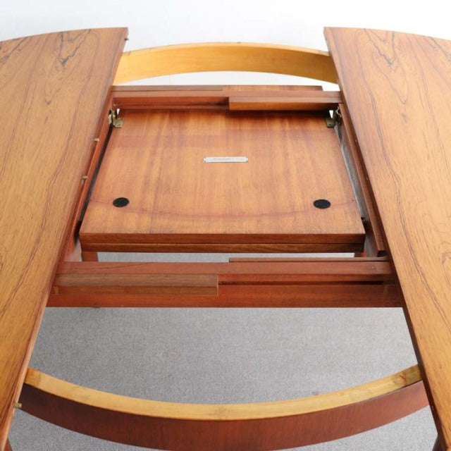 Mid-century British vintage teak round dining table with extension mechanism and curved legs, Denmark design influence.