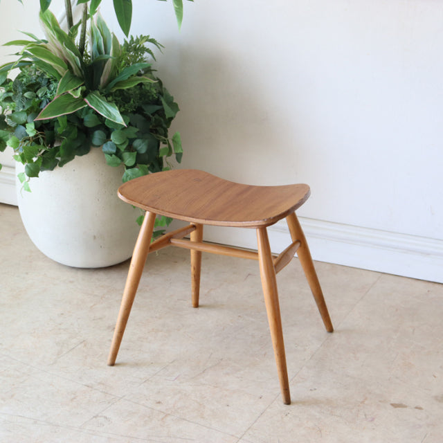 Vintage Arcol mid-century teak butterfly stool with gracefully tapered legs and smooth wood grain finish, British design.