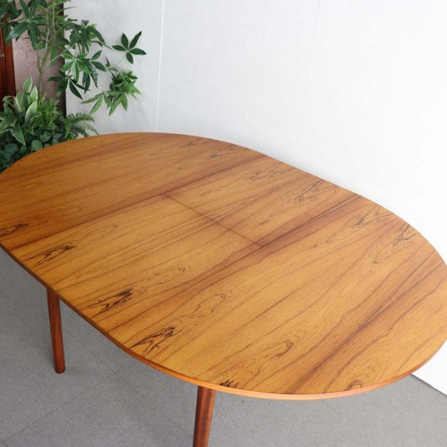 Vintage mid-century teak round dining table by McIntosh with rich wood grain and slender tapered legs, British-Denmark style.
