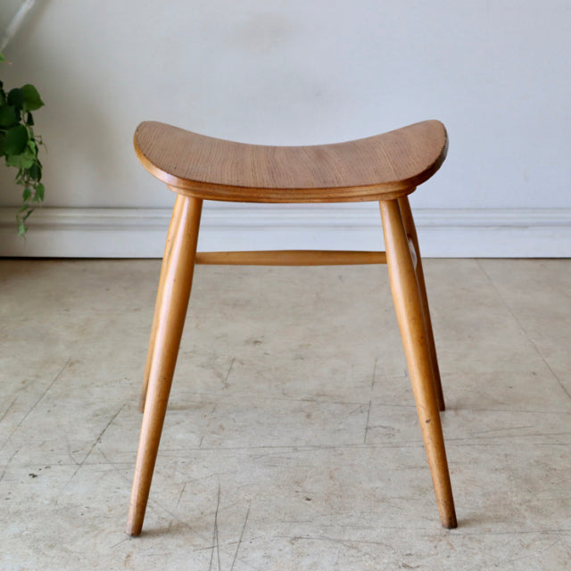 Mid-century British vintage ERCOL butterfly stool in teak with sculpted seat and tapered legs.