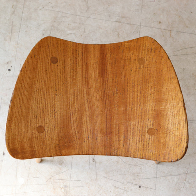 Vintage Ercol mid-century teak butterfly stool seat showing smooth wood grain and natural finish.