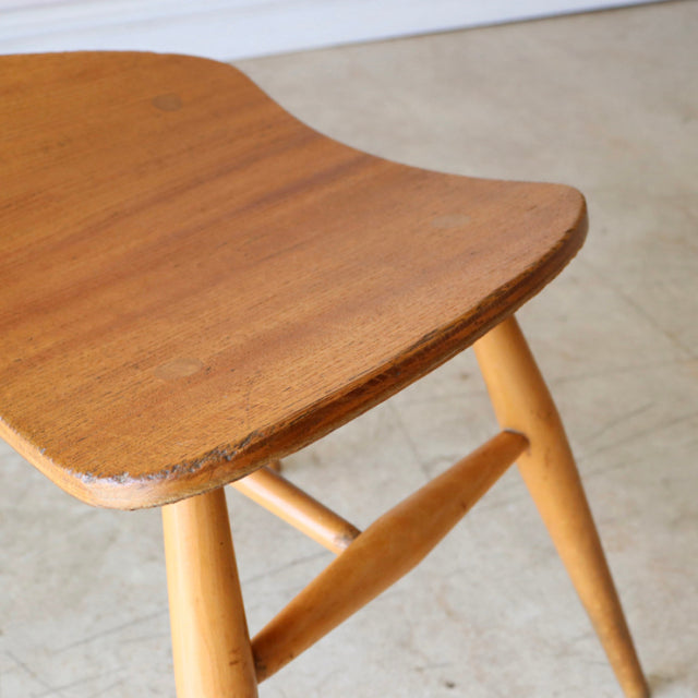 Vintage ERCOL butterfly stool in teak with smooth wood grain, angled mid-century British legs, and Scandinavian design.