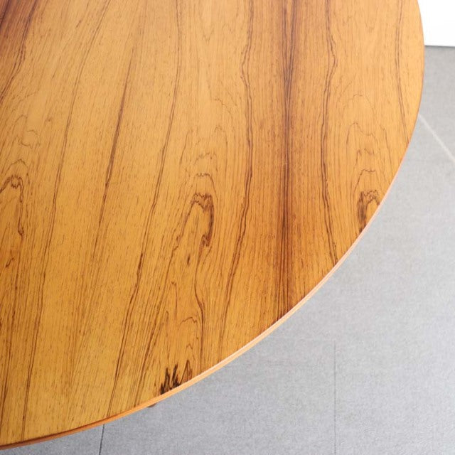 Vintage teak round dining table showcasing rich wood grain and smooth finish, mid-century British design.