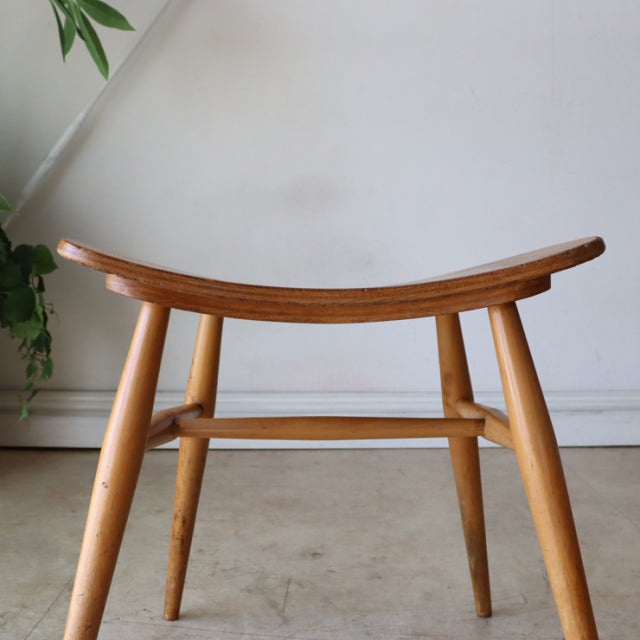 Vintage ERCOL mid-century teak butterfly stool with curved seat, tapered legs, and sturdy crossbars, British design.
