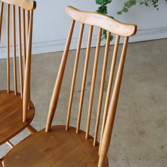 Set of four vintage British mid-century Ercol Goldsmith highback dining chairs in natural teak with slender vertical spindle .